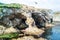 Tourists/trekers evaluating natural arches. Aerial of cape Ptichiy Velikan, Sakhalin island, Russia. Surrealistic landscape.