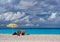 Tourists under a beach umbrella and Beautiful beach Myrtos with clear turquoise water on a sunny day in the Ionian Sea on the