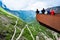 Tourists on viewpoint over Trollstigen or Troll Stairs, a serpentine mountain road that is popular tourist attraction in Norway