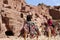 Tourists visiting the ancient ruins of Petra on camels , Jordan