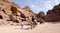 Tourists visiting the ancient ruins of Petra on camels , Jordan