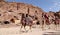 Tourists visiting the ancient ruins of Petra on camels , Jordan