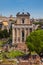 Tourists visiting the Roman Forum and the Temple of Antoninus and Faustina in Rome