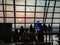 Tourists waiting for morning flight at the airport gate and they looking through the window glass to see the beautiful of sunrise.