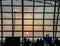 Tourists waiting for morning flight at the airport gate and they looking through the window glass to see the beautiful of sunrise.