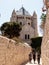 Tourists walk along the passage along the narrow street Ma`ale HaShalom to the Dormition abbey in old tow in Jerusalem