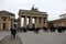 Tourists walk through and around the Brandenburg Gate on Unter den Linden in central Berlin