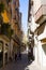 Tourists walk on narrow street in old medvedial town in Girona