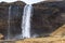 Tourists walk near Seljalandfoss waterfall