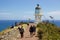 Tourists walk toward lighthouse at Cape Reinga, Northland, New Zealand