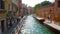 Tourists are walking along the canal in Venice, Italy