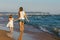 Tourists walking along the coastline on a sunny summer evening