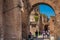 Tourists walking by the archway at Via Nova on the ancient Roman Forum in Rome