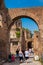 Tourists walking by the archway at Via Nova on the ancient Roman Forum in Rome