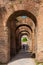 Tourists walking by the archway at Via Nova on the ancient Roman Forum in Rome