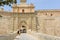 Tourists walking through Baroque portal of Mdina Gate, also known as the Main Gate or the Vilhena Gate