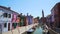 Tourists walking on beautiful street with colorful houses in Burano, Venice