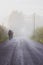 Tourists walking in fog. Backpackers on the road in foggy morning and sunlight. Pilgrims on Camino de Santiago. Active lifestyle.