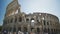 Tourists walking near ancient amphitheater Coliseum in Italy, enjoying tour