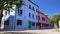 Tourists walking near beautiful tidy colorful houses on Burano island, Venice