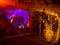 Tourists walking on path among the illuminated stalactites and stalagmites