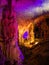 Tourists walking on path among the illuminated stalactites and stalagmites