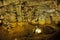 Tourists walking on stalactites cave looking infernal