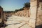 Tourists wallking past alley of Greek-Roman city Ephesus with stone sculptures