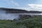 Tourists watching and admiring the powerful waterfall Dettifoss in Iceland