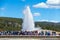 Tourists watching the Old Faithful erupting in Yellowstone National Park