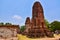 Tourists are watching the ruins of the pagoda and the Buddha statue in Wat Mahathat,