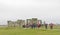 Tourists watching the stone monument Stonehenge a cloudy day, built in the late Neolithic period, around 2500 BC for unknown