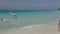 Tourists on water activities in Atlantic Ocean. Surfing exercising. Turquoise ocean water surface merging with blue sky.