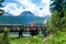 Tourists on wooden footbridge over stream. Meded Peak and Glacial Black Lake background. Durmitor National Park. Montenegro