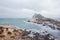 Tourists at the Yeliu Yehliu Geopark in Wanli District, New Taipei, Taiwan at a rainy, windy and overcast day.