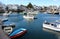 Touristy scene with fishing and row boats moving about on calm waters, Rockport, Massachusetts, 2018