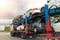 Tow truck car carrier semi trailer on highway carrying batch of damaged cars sold on insurance car auctions for repair and