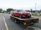 A tow truck car transporter, lorry carrying a car for repairing at the city street