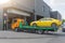 Tow truck drives into an underground garage with a loaded yellow car