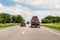 Tow truck trailer on highway carrying three damaged cars sold on insurance car auctions for repair and recovery.  Vehicles