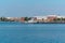 Towboat pushes dry bulk cargo barge on the river past the industrial landscape