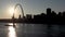 Towboat pushing barge loaded with corn grain down Mississippi River, passing St. Louis Gateway Arch