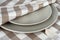 Towel in beige plaid and gray plates. Kitchen towel and plates.
