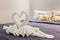 Towel folded in swan shape on bed sheet