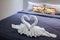 Towel folded in swan shape on bed sheet