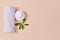 Towel and tubes with cream. Leaf as symbol for organic. Wellness and beauty concept. Copy space on pink backdrop