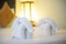 Towels in form of elephants on luxury bed in tropical beach hotel