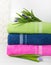 Towels in stack against the blured backdrop, stack of green, blue, yelloy and pink towels with flowers