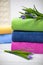 Towels in stack against the blured backdrop. Stack of green, blue, yelloy and pink towels with flowers