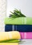 Towels in stack against the blured backdrop, stack of green, blue, yelloy and pink towels with flowers